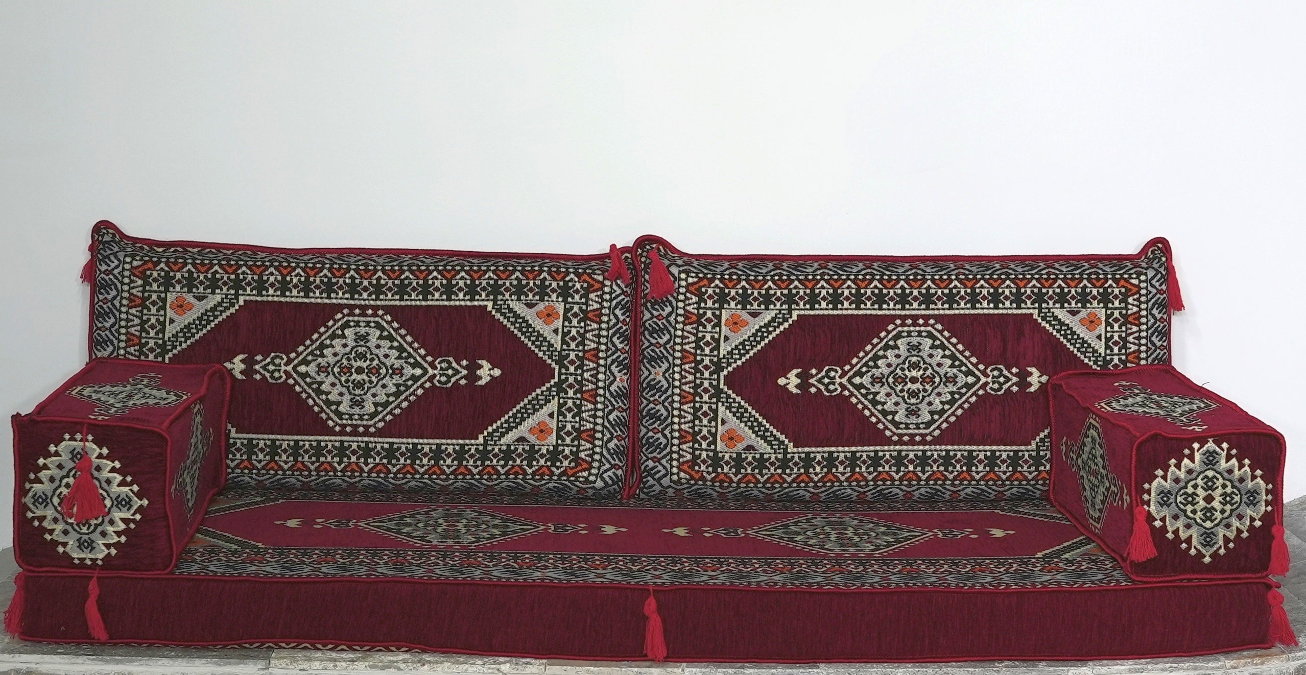 A traditional Persian-style floor majlis sofa in burgundy, deep red with intricate Turkish Palace patterns.