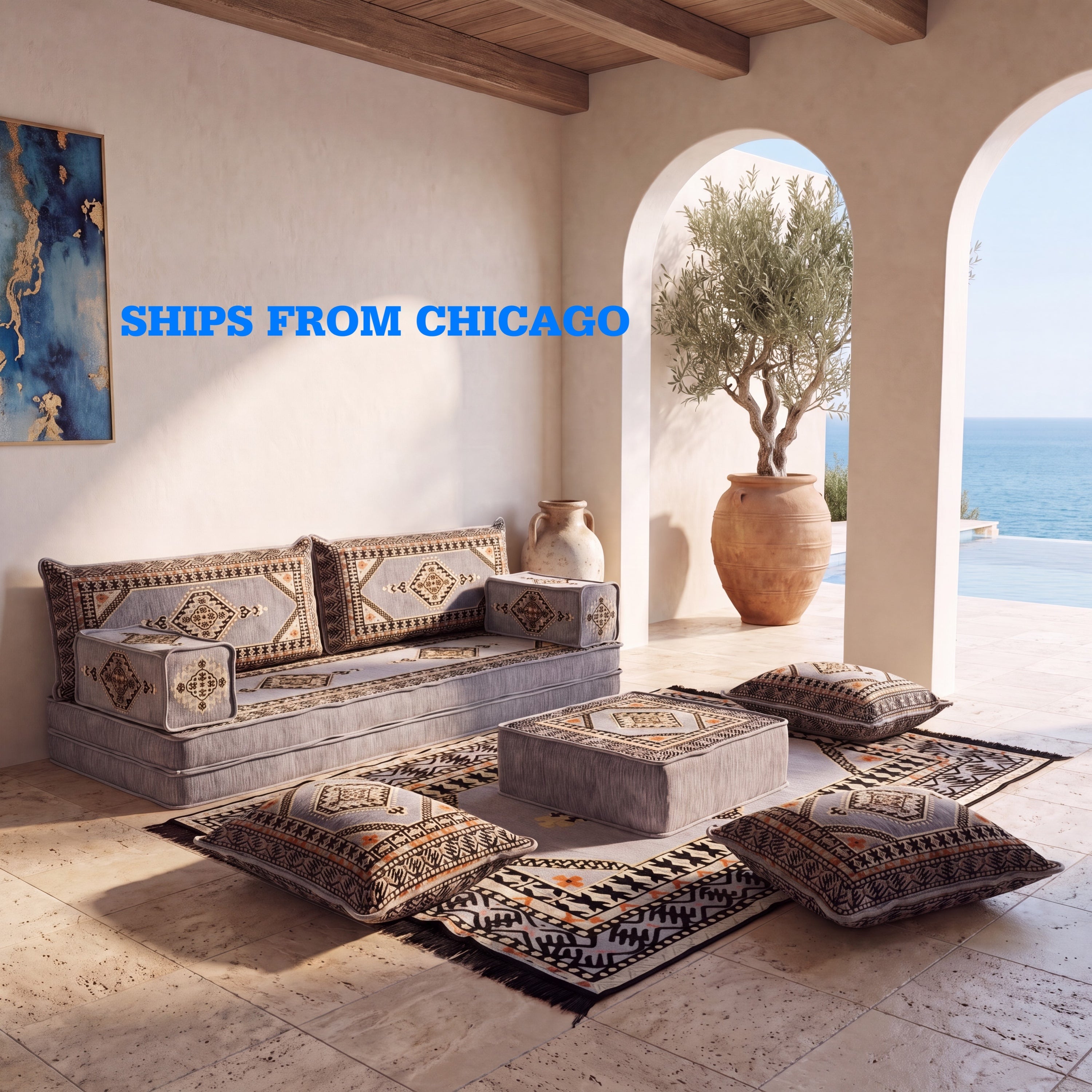 A Mediterranean-style outdoor seating arrangement featuring a gray ARABIC FLOOR sofa with FLOOR cushions, matching floor pillows, a ottoman, and A patterned KILIM rug with blue text overlay reading 'SHIPS FROM CHICAGO'.
