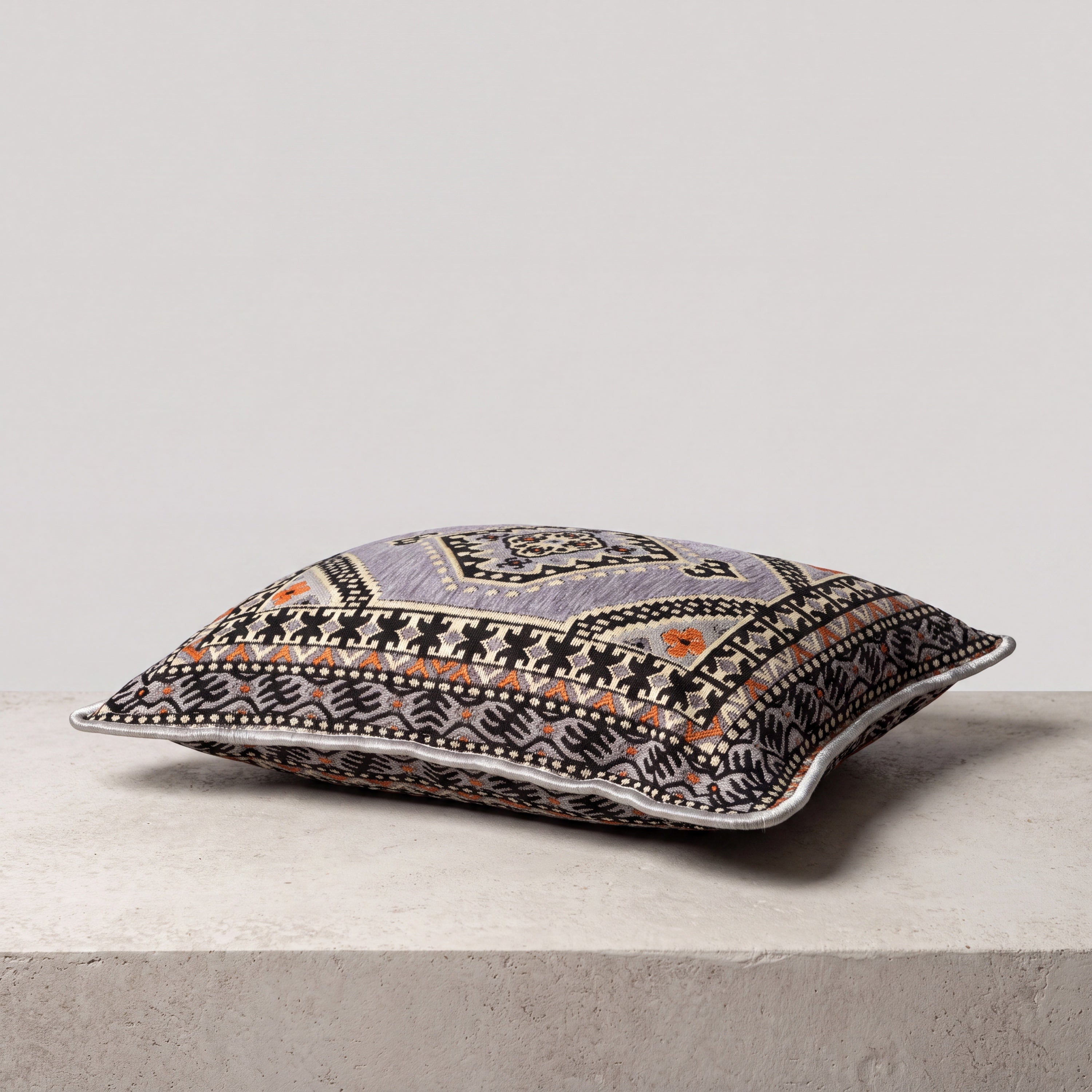 A rectangular decorative Turkish throw pillow with a detailed geometric and tribal pattern in black, gray, beige, and orange.